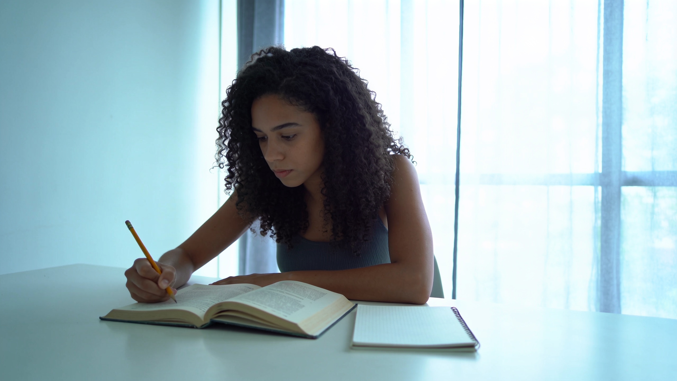 Pessoa estudando com um livro aberto sobre a mesa